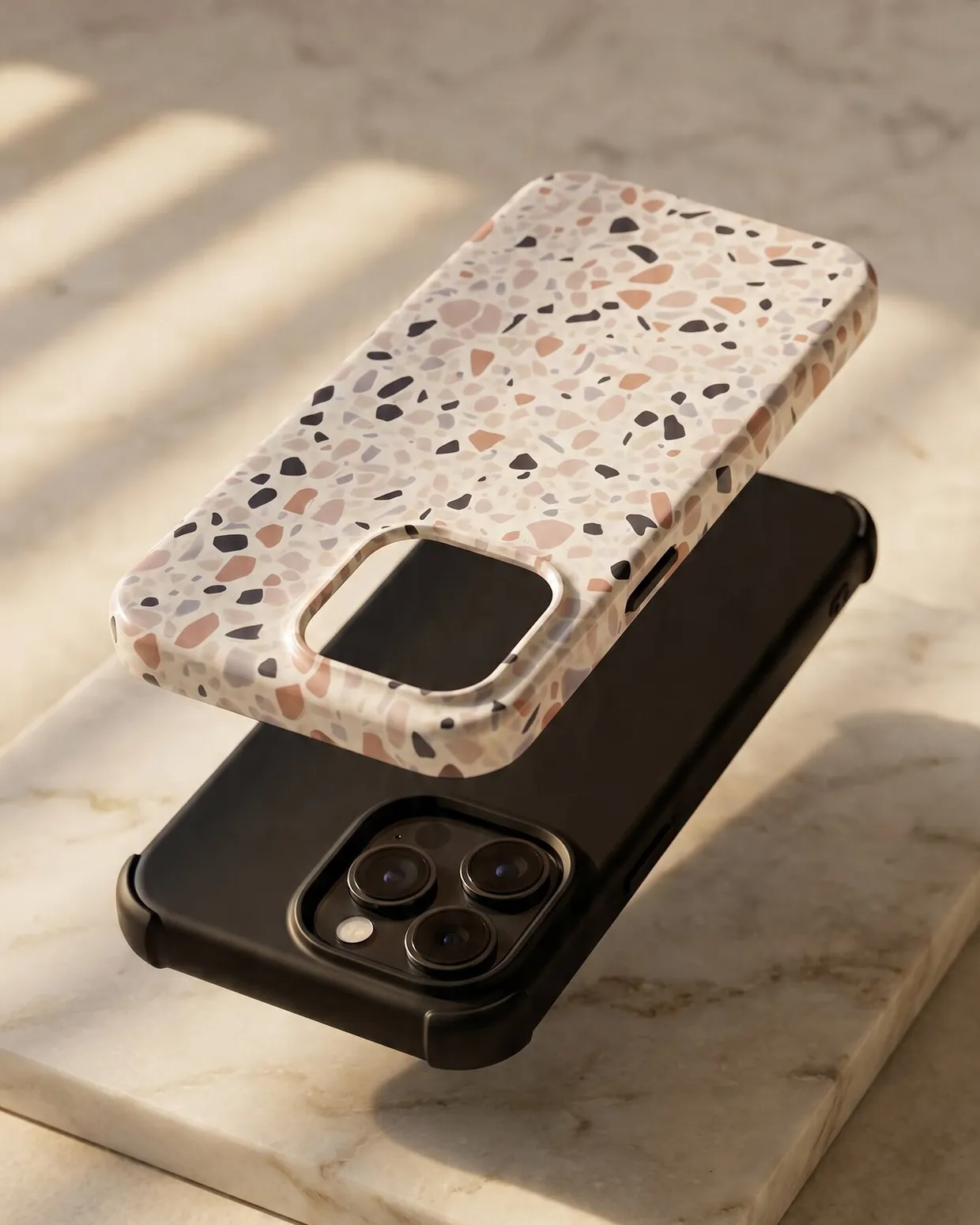 Dual-layer iPhone case construction — patterned hard shell lifted above the black shock-absorbing inner liner